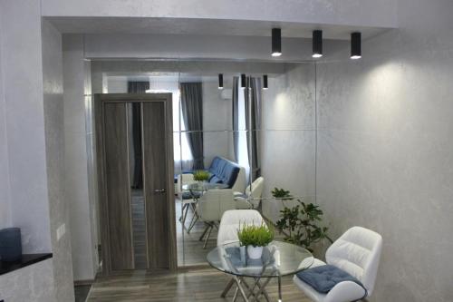 a living room with white chairs and a table at New luxury Apartment in the Center on Konstitution Square in Kharkiv