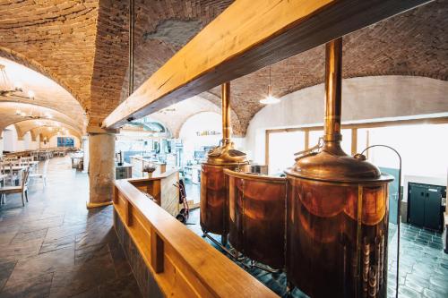a row of wine barrels in a room with a bar at Dvůr Perlová voda in Budyně nad Ohří