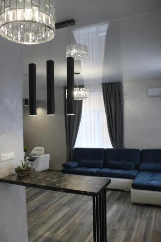 a living room with a blue couch and a table at New luxury Apartment in the Center on Konstitution Square in Kharkiv