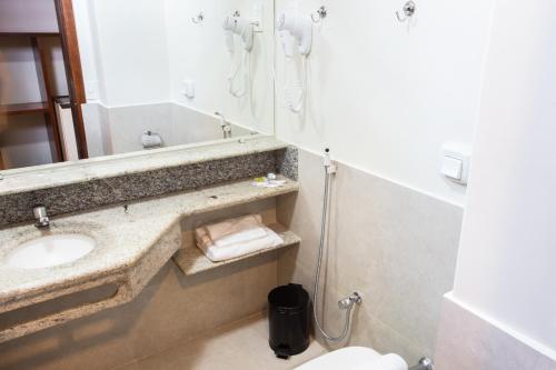 a bathroom with a sink and a mirror at Carlton Plaza Hotel Uberlandia in Uberlândia