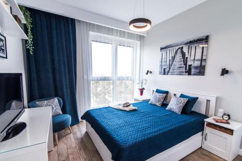 a bedroom with a blue bed and a window at Panorama Suite - Top Apartment - Gliwice in Gliwice