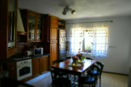 a kitchen with a table and chairs and a kitchen with a window at Casa Smeilor Horezu in Horezu