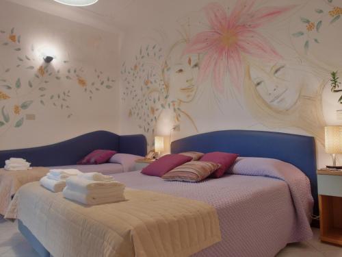 Hotel Julia في ليدو ديلي ايستينسي: غرفة نوم عليها سرير وفوط