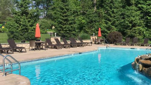 una piscina con sedie e ombrelloni di Woodfield Manor - A Sundance Vacations Property a Cresco