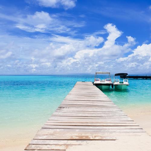 two boats sitting on a dock in the ocean at Thundi Sea View in Fulidhoo