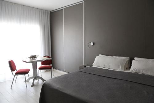 1 dormitorio con 1 cama y 1 mesa con sillas en Termas de Miraflores Hotel Termal en Termas de Río Hondo