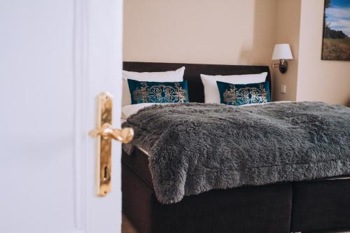 a bedroom with a bed with a gray blanket and pillows at Landfein-Villa Marathon in Winterberg