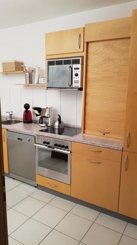 een keuken met een fornuis en een magnetron bij Ferienwohnung Lorenz in Oberhausen