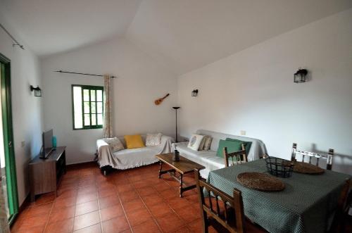 ein Wohnzimmer mit einem Sofa und einem Tisch in der Unterkunft Casa Caballería in Vallebrón