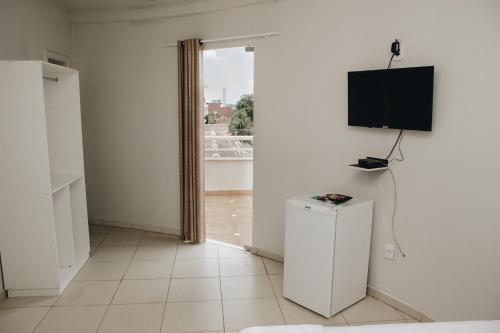 a white room with a television on a wall at SAMIR HOTEL COMFORT in Porto Velho