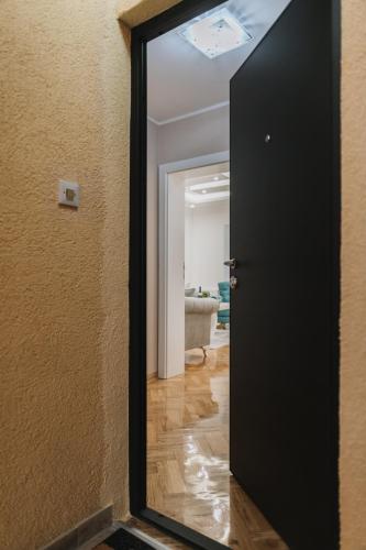 une porte noire avec un miroir dans une pièce dans l'établissement Three Sons Apartment, à Novi Sad