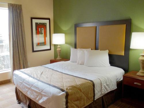 a large bed in a hotel room with two lamps at Suburban Studios Jackson North in Jackson