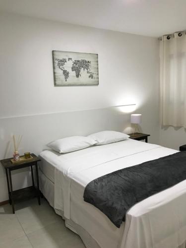 um quarto com uma cama grande e uma fotografia na parede em Apartamento Completo Jatiúca em Maceió