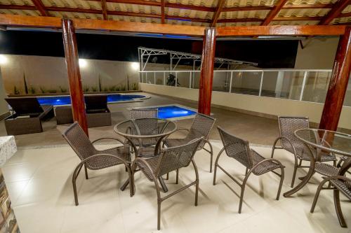 a room with a table and chairs and a pool at Pousada Recanto das Caldas in Caldas Novas