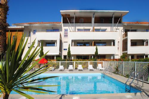 un edificio con piscina frente a un edificio en Résidence Néméa Les Terrasses de l'Océan, en Moliets-et-Maa