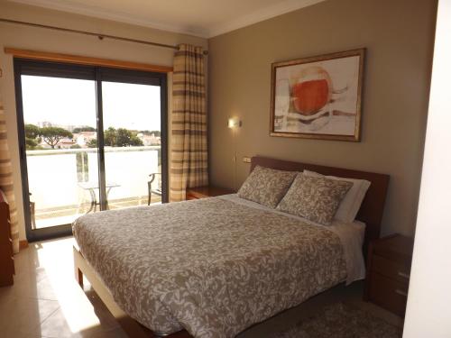 Sea View Oceanus Apartment Olhos de Agua tesisinde bir odada yatak veya yataklar