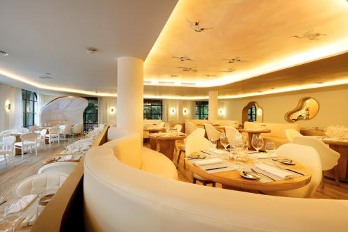 a restaurant with wooden tables and white chairs at TRS Yucatan Hotel - Adults Only in Akumal