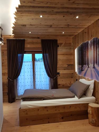 a bedroom with a bed in a wooden room at AGRITURISMO La Giasena in Ponte nellʼAlpi