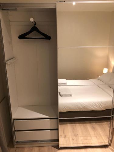 - une chambre avec un lit et un miroir dans l'établissement GH Apartment Pasteur-Montparnasse, à Paris