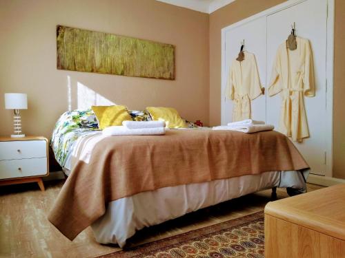 um quarto com uma cama com roupas penduradas na parede em Vintage Bariloche Hostel Boutique em San Carlos de Bariloche