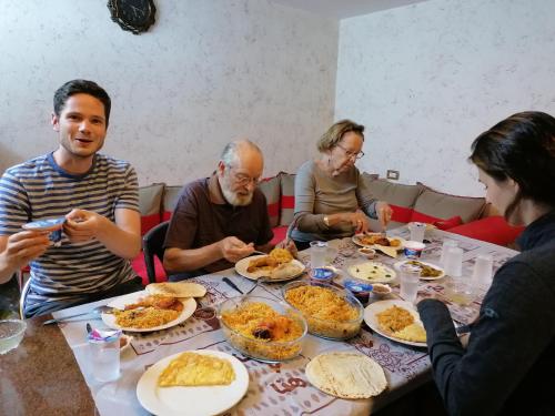 a group of people sitting around a table eating food at Mhna guest house in Ajloun