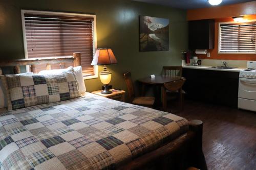 a bedroom with a large bed and a kitchen at Lone Fir Resort in Cougar