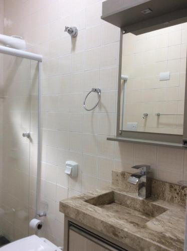 ein Bad mit einem Waschbecken und einem Spiegel in der Unterkunft RESIDENCIAL ANNABEL APTO 03 in Bombinhas
