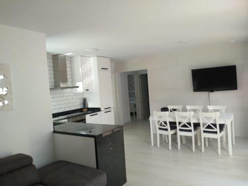 a kitchen and a living room with a table and chairs at Villa maravillosa in San Bartolomé de Tirajana