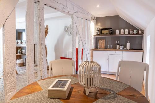 une pièce avec une table et des chaises et une cuisine dans l'établissement LE BALDAQUIN / Les Suites Romantiques Honfleur, à Honfleur