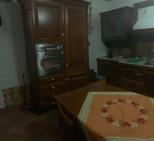 a kitchen with a table and a microwave at Airport Tourist's Home in Catania