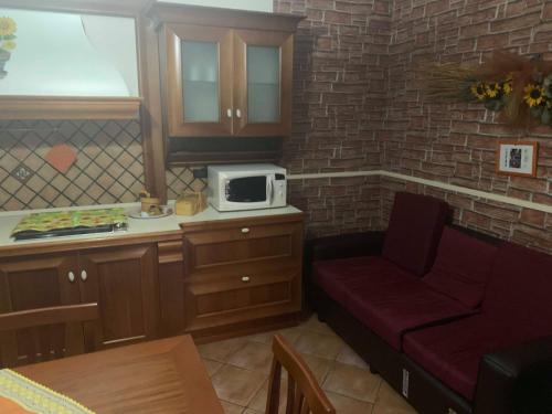 a kitchen with a stove top oven and a microwave at Airport Tourist's Home in Catania