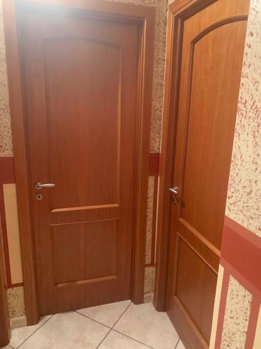 a pair of wooden doors in a room at Airport Tourist's House in Catania