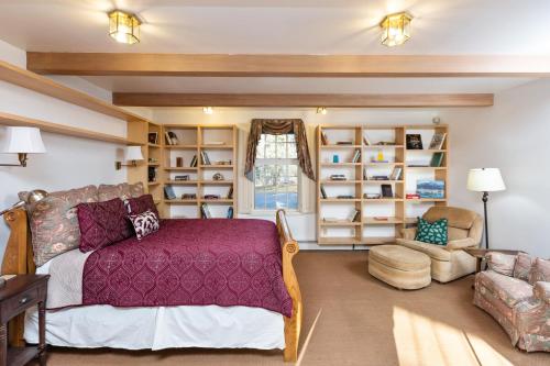1 dormitorio con cama, silla y estanterías en Anchorage Escape en Anchorage