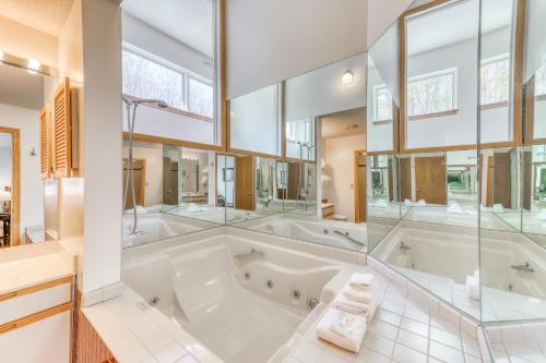 a large bathroom with a large tub and glass walls at The Woods: D4 in Killington