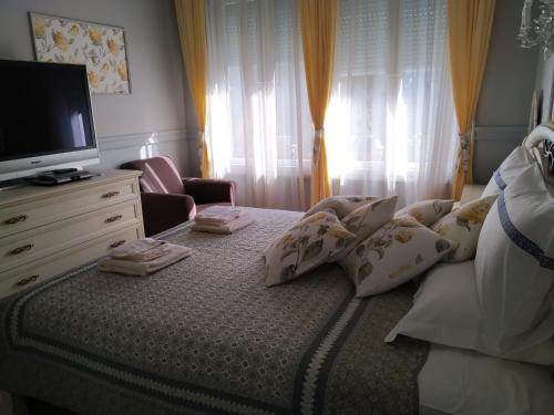 a bedroom with a bed with pillows and a television at My Home, with free secure parking in Stara Zagora