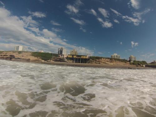 a body of water with a beach in the background at Apartamento Costa del Sol in Mar del Plata