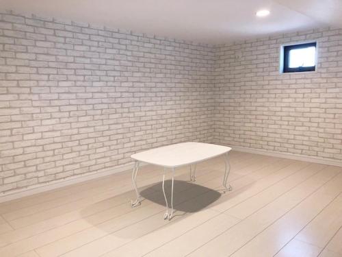a white table in a room with a brick wall at ラ・マーレ福津海岸通り201 in Tsuyazaki