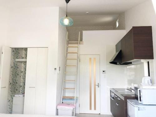 a kitchen with a ladder in the corner of a room at ラ・マーレ福津海岸通り201 in Tsuyazaki