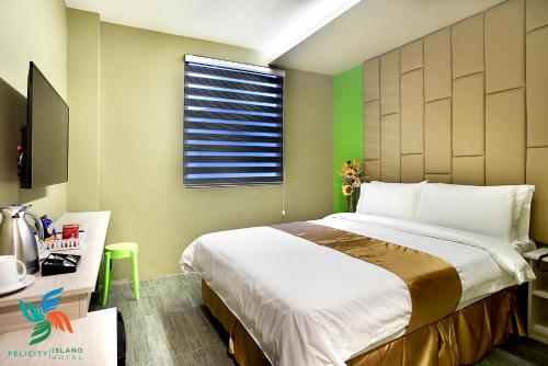 een slaapkamer met een groot bed en een raam bij Felicity Island Hotel in Mactan