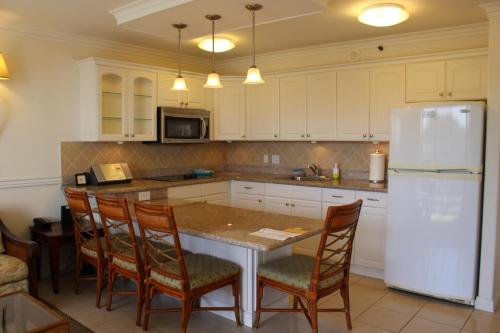 a kitchen with a table and chairs and a refrigerator at PonoAloha in Honolulu