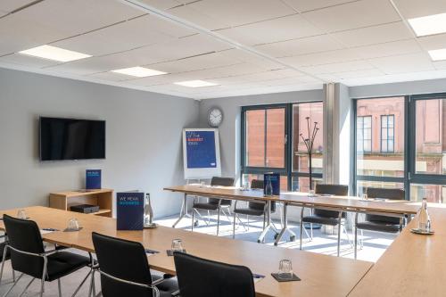 a conference room with tables and chairs and a tv at Holiday Inn Express - Derry - Londonderry by IHG in Derry Londonderry