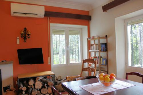 a living room with orange walls and a table and a television at Viña Concepción in Andújar
