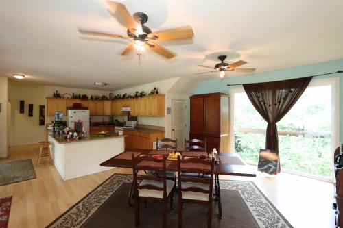 a kitchen with a table and a ceiling fan at Volcano Forest Inn in Volcano