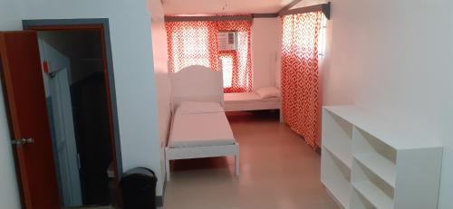 a small room with a bench and a bed at Bella's Beach Resort (A) in Bauang