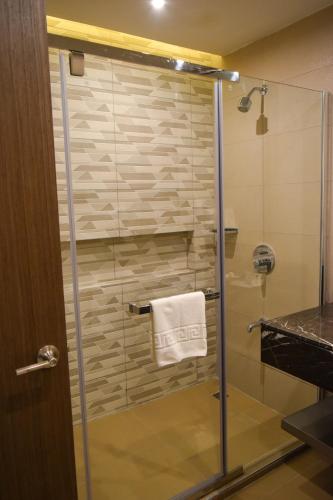 a glass shower with a towel on a towel rack at Zuri Hotel in Iloilo City