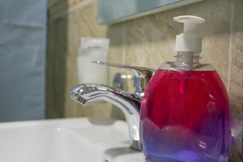 a bottle of soap sitting on top of a sink at Astana Hotel in Almaty