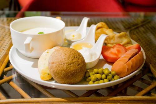 a plate of food with a cup of tea and vegetables at Astana Hotel in Almaty
