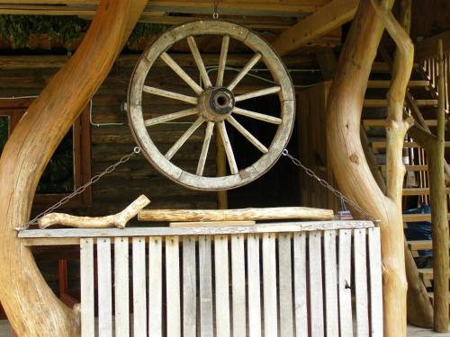 a wooden wagon wheel hanging from the ceiling of a cabin at Likimo ratas in Paliepis