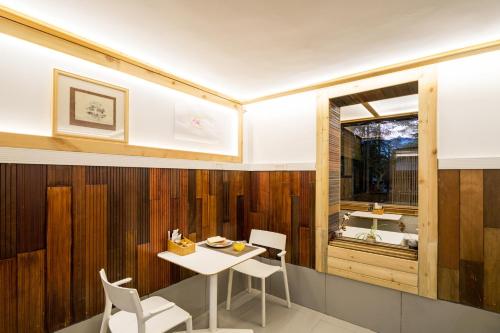 a dining room with a table and chairs and a window at Zen Tea House Seven Stars Park in Guilin