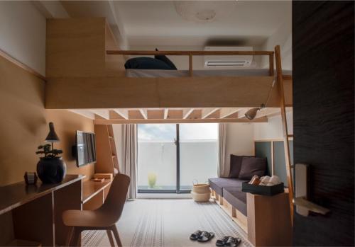 a small room with a bunk bed and a desk at EARTHMANS OSAKA-JO in Osaka